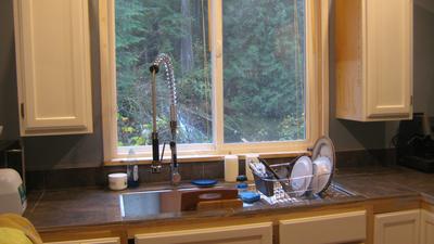 Kitchen looks out onto the river, forrest, and waterfall